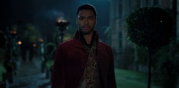 Movie still from “Bridgerton” (2020), created by Chris Van Dusen – A man in a red jacket standing in front of a building; Medium shot, Over the shoulder angle