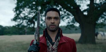 Movie still from “Bridgerton” (2020), created by Chris Van Dusen – A man holding a rifle in a field; Close Up shot, Low angle