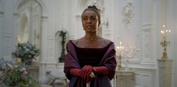 Movie still from “Bridgerton” (2020), created by Chris Van Dusen – An older woman in a purple dress and red gloves; Medium shot, Low angle