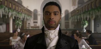 Movie still from “Bridgerton” (2020), created by Chris Van Dusen – A man wearing a black jacket and a white neck tie; Close Up shot, Low angle