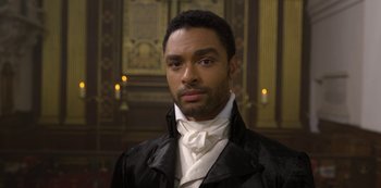 Movie still from “Bridgerton” (2020), created by Chris Van Dusen – A man wearing a black jacket and a white neck tie; Close Up shot, High angle