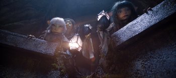 Movie still from “The Dark Crystal: Age of Resistance” (2019), created by Jim Henson – A group of people standing next to each other in a room; Wide shot, High angle