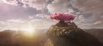 Movie still from “The Dark Crystal: Age of Resistance” (2019), created by Jim Henson – A pink tree on top of a mountain with a cloudy sky; Extreme Wide shot, Low angle