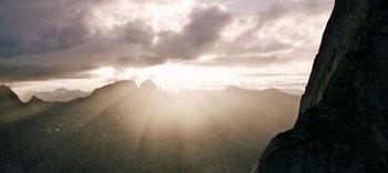Movie still from “The Dark Crystal: Age of Resistance” (2019), created by Jim Henson – The sun is shining through the clouds on a mountain top; Extreme Wide shot, Low angle