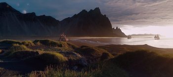 Movie still from “The Dark Crystal: Age of Resistance” (2019), created by Jim Henson – A view of a mountain range and a body of water at sunset; Extreme Wide shot, Low angle