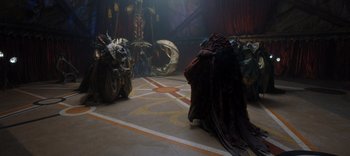 Movie still from “The Dark Crystal: Age of Resistance” (2019), created by Jim Henson – A group of people standing around in a room; Wide shot, High angle