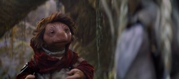 Movie still from “The Dark Crystal: Age of Resistance” (2019), created by Jim Henson – An image of an animated creature in a forest setting; Close Up shot, Over the shoulder angle