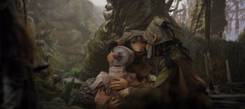 Movie still from “The Dark Crystal: Age of Resistance” (2019), created by Jim Henson – A woman holding a stuffed animal in her arms; Medium shot, High angle