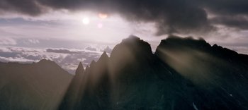 Movie still from “The Dark Crystal: Age of Resistance” (2019), created by Jim Henson – The sun is shining through the clouds on a mountain top; Extreme Wide shot, Low angle