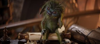 Movie still from “The Dark Crystal: Age of Resistance” (2019), created by Jim Henson – A small green creature sitting on top of a piece of wood; Close Up shot, High angle
