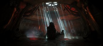 Movie still from “The Dark Crystal: Age of Resistance” (2019), created by Jim Henson – A person sitting in a room with lights shining on them; Extreme Wide shot, Low angle