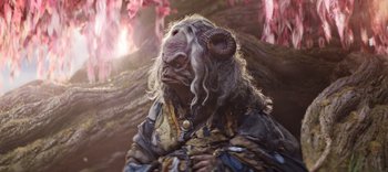 Movie still from “The Dark Crystal: Age of Resistance” (2019), created by Jim Henson – A person with a horned animal mask on; Medium shot, High angle