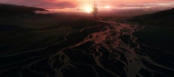 Movie still from “The Dark Crystal: Age of Resistance” (2019), created by Jim Henson – The sun is setting over the ocean with a castle in the background; Extreme Wide shot, High angle