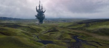 Movie still from “The Dark Crystal: Age of Resistance” (2019), created by Jim Henson – An aerial view of a large castle on a green field; Extreme Wide shot, High angle