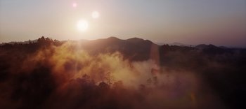 Movie still from “The Dark Crystal: Age of Resistance” (2019), created by Jim Henson – The sun is setting over the mountains and trees in the fog; Extreme Wide shot, Low angle