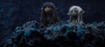 Movie still from “The Dark Crystal: Age of Resistance” (2019), created by Jim Henson – A couple of people standing next to each other on top of a rock; Medium shot, High angle