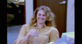 Movie still from “Air” (2023), directed by Ben Affleck – A woman smiling while holding a water bottle; Close Up shot, Over the shoulder angle