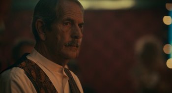 Movie still from “Air” (2023), directed by Ben Affleck – An older man wearing a vest and a tie; Close Up shot, Over the shoulder angle