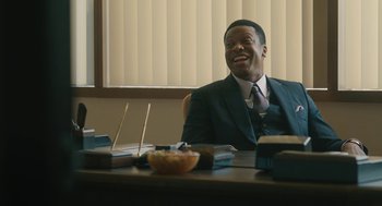 Movie still from “Air” (2023), directed by Ben Affleck – A man sitting at a table in front of a bowl of food; Medium shot, Over the shoulder angle