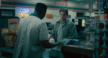 Movie still from “Air” (2023), directed by Ben Affleck – A man is paying for something at a store; Medium shot, Over the shoulder angle