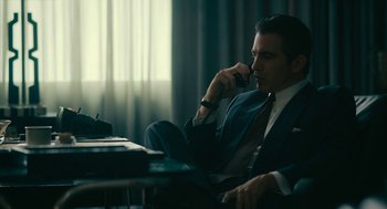 Movie still from “Air” (2023), directed by Ben Affleck – A man sitting in a chair talking on a phone; Medium shot, Low angle