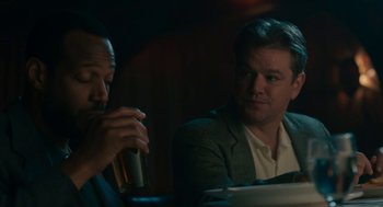 Movie still from “Air” (2023), directed by Ben Affleck – Two men are sitting at a table and one is holding a drink; Close Up shot, Over the shoulder angle