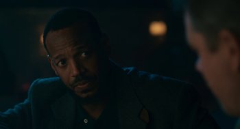 Movie still from “Air” (2023), directed by Ben Affleck – A man in a suit looking at something in the dark; Close Up shot, Over the shoulder angle
