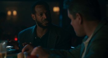 Movie still from “Air” (2023), directed by Ben Affleck – Two men sitting at a table talking to each other; Medium shot, Over the shoulder angle