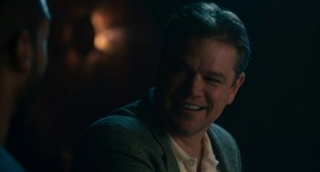Movie still from “Air” (2023), directed by Ben Affleck – A person wearing a suit and smiling; Close Up shot, Over the shoulder angle