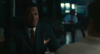 Movie still from “Air” (2023), directed by Ben Affleck – A man sitting at a table in a suit and tie; Close Up shot, Over the shoulder angle