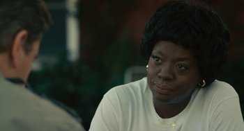 Movie still from “Air” (2023), directed by Ben Affleck – A woman with a cross on her head sitting in a room; Close Up shot, Over the shoulder angle