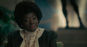Movie still from “Air” (2023), directed by Ben Affleck – A woman sitting in a chair wearing a black jacket; Close Up shot, Over the shoulder angle