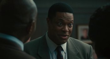 Movie still from “Air” (2023), directed by Ben Affleck – A man in a suit and tie looking surprised; Close Up shot, Over the shoulder angle