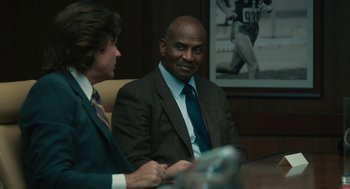 Movie still from “Air” (2023), directed by Ben Affleck – Two men sitting at a table in a room; Medium shot, Over the shoulder angle