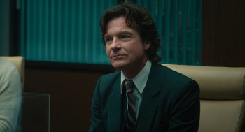 Movie still from “Air” (2023), directed by Ben Affleck – A man wearing a suit and tie sitting in a chair; Close Up shot, Low angle