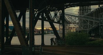 Movie still from “Air” (2023), directed by Ben Affleck – Two people standing on a train track under a bridge; Extreme Wide shot, High angle