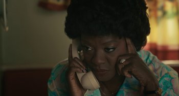 Movie still from “Air” (2023), directed by Ben Affleck – An older woman talking on a phone while sitting down; Close Up shot, High angle