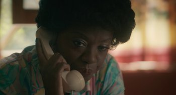 Movie still from “Air” (2023), directed by Ben Affleck – An older woman talking on a phone while sitting in a chair; Close Up shot, High angle