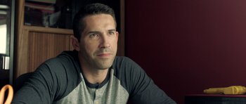 Movie still from “The Debt Collector” (2018), directed by Jesse V. Johnson – A person sitting in front of a wall; Close Up shot, Over the shoulder angle