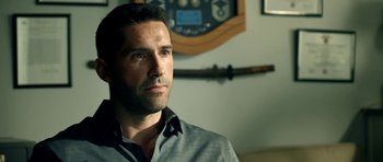 Movie still from “The Debt Collector” (2018), directed by Jesse V. Johnson – A person wearing a dress shirt; Close Up shot, Over the shoulder angle