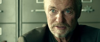 Movie still from “The Debt Collector” (2018), directed by Jesse V. Johnson – An older man with a beard and blue eyes; Close Up shot, Over the shoulder angle