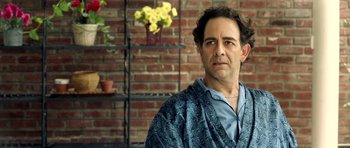 Movie still from “The Debt Collector” (2018), directed by Jesse V. Johnson – A person wearing a robe near a brick wall; Close Up shot, Over the shoulder angle