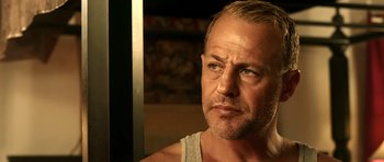 Movie still from “The Debt Collector” (2018), directed by Jesse V. Johnson – A person wearing a tank top; Close Up shot, Low angle