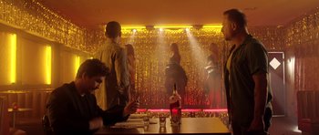 Movie still from “The Debt Collector” (2018), directed by Jesse V. Johnson – A group of people standing around a bar; Wide shot, Low angle