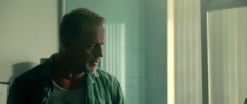 Movie still from “The Debt Collector” (2018), directed by Jesse V. Johnson – A person wearing a green shirt; Close Up shot, Over the shoulder angle