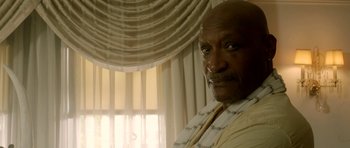 Movie still from “The Debt Collector” (2018), directed by Jesse V. Johnson – An older man with a beard is standing in front of a window; Close Up shot, Low angle