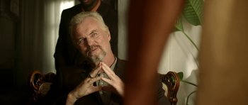 Movie still from “The Debt Collector” (2018), directed by Jesse V. Johnson – An older man with white hair is holding a cell phone; Close Up shot, Over the shoulder angle