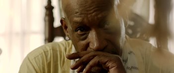 Movie still from “The Debt Collector” (2018), directed by Jesse V. Johnson – An older bald man with his hand to his face; Extreme Close Up shot, High angle
