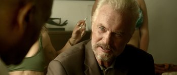 Movie still from “The Debt Collector” (2018), directed by Jesse V. Johnson – An older man with white hair and blue eyes talking on a cell phone; Close Up shot, Over the shoulder angle
