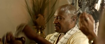 Movie still from “The Debt Collector” (2018), directed by Jesse V. Johnson – An older black man wearing a yellow robe; Close Up shot, Over the shoulder angle